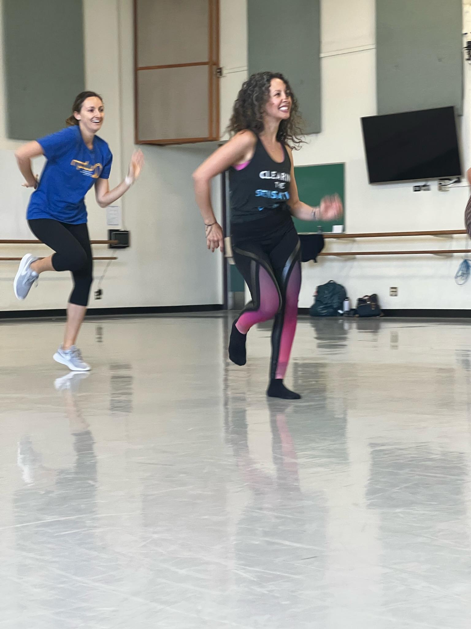 Two dancers perform in a studio.