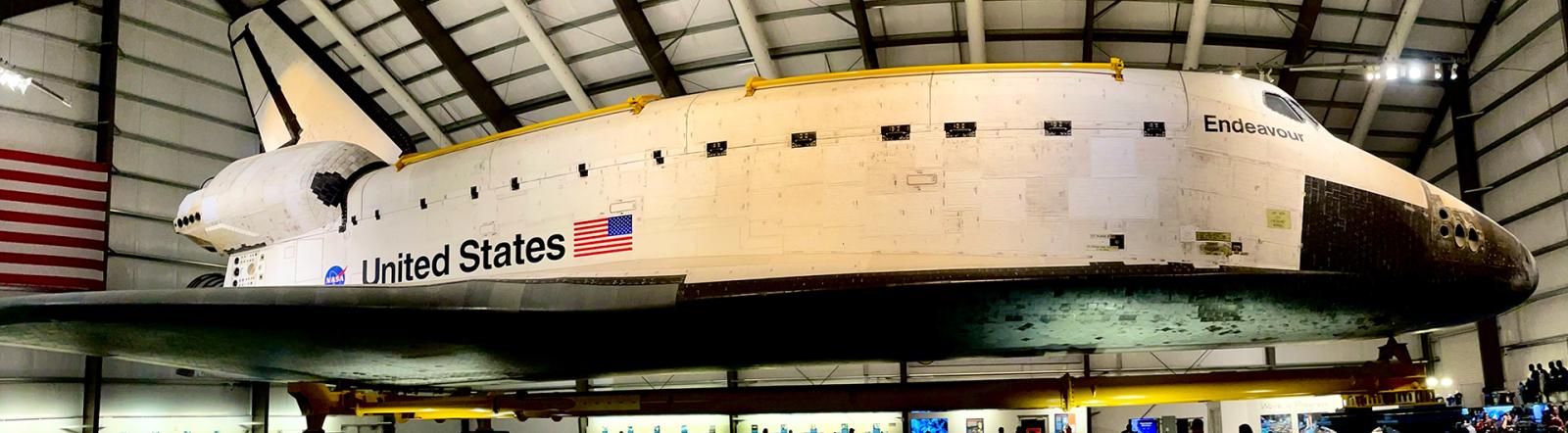 A wide angle shot of a space shuttle in a museum.