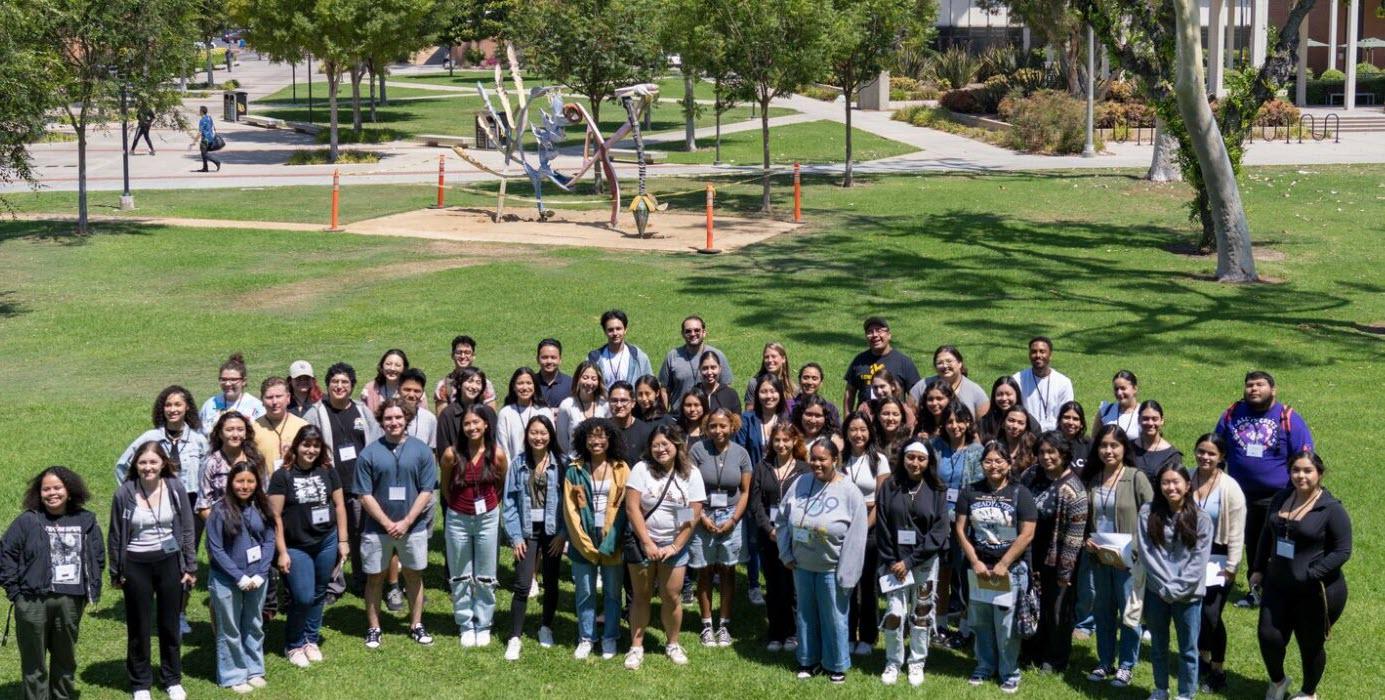 panoramic view of a large group of students standing on grass