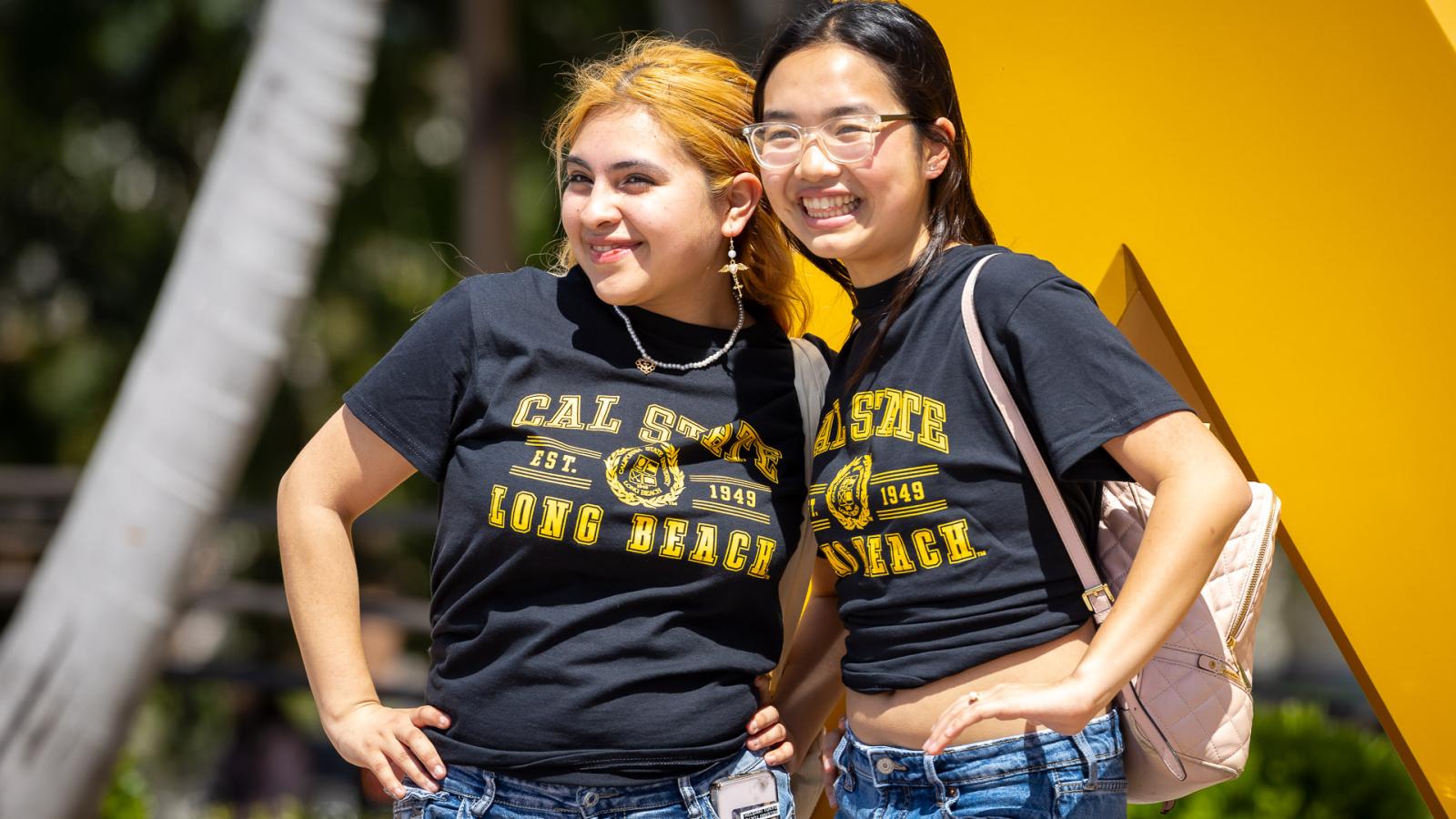 Two students standing in front of the Go Beach sign.