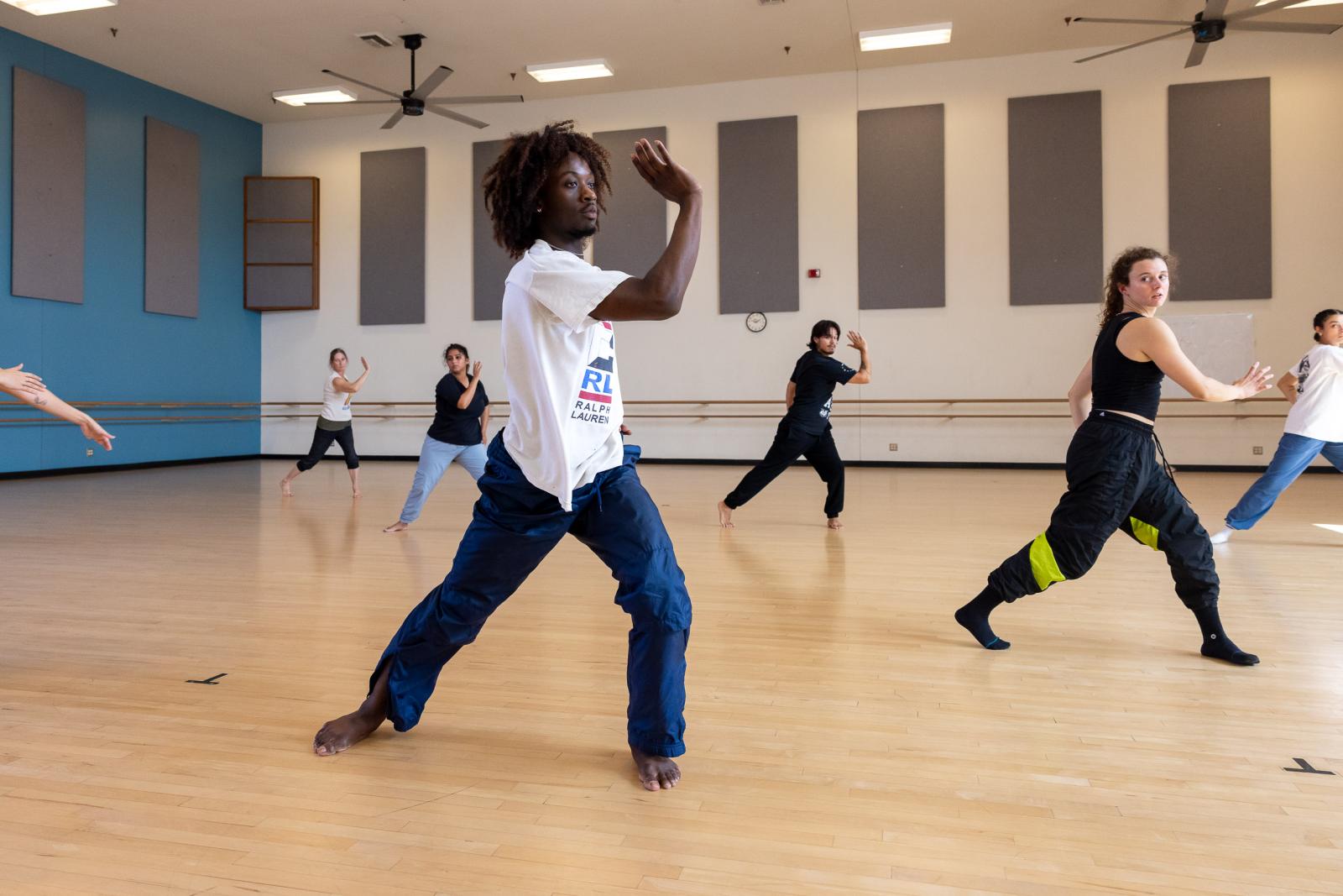 Mykiah Goree of A.I.M helps warm up MFA dance students