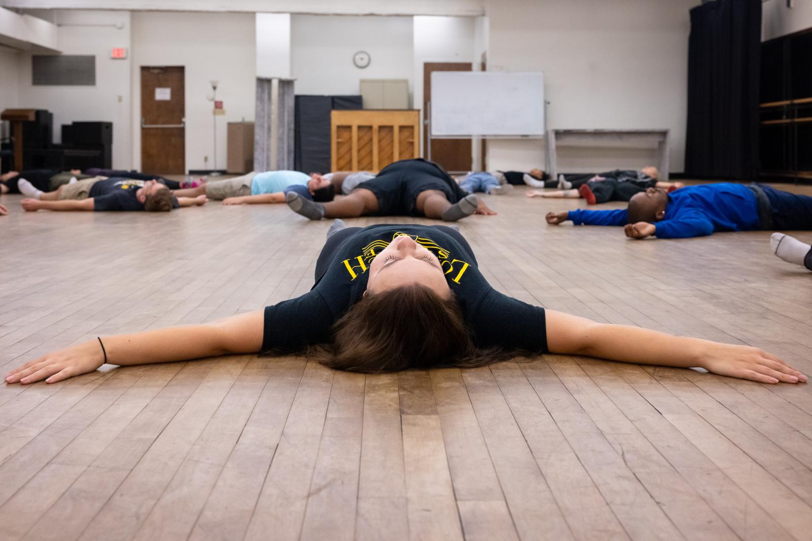 Theater students stretching on the floor 