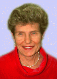 Dr. Haglund is a white woman with short, light-brown hair. She is wearing a red blouse with pearl earrings and necklace