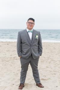 Photograph of Project Rebound's Social Worker, Ruben Guerrero. He is depicted by the beach in a grey suit.